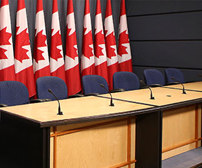 Conference table with row of Canadian flags